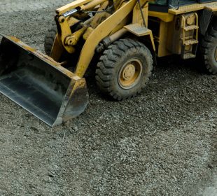 the tractor is leveling the road from the stones