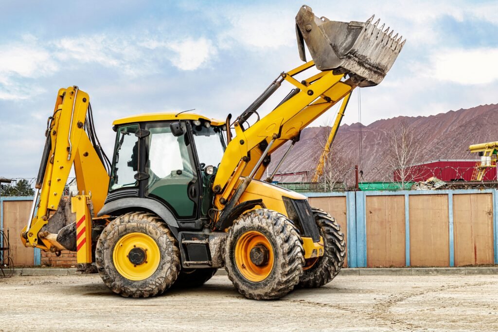 Backhoe rental driving in a construction yard