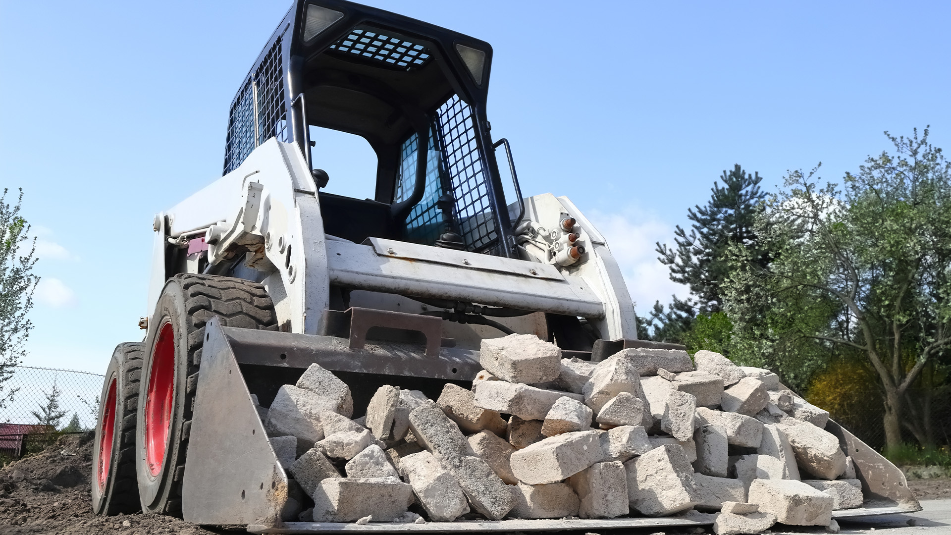 skid steer from trs equipment rental moving rocks