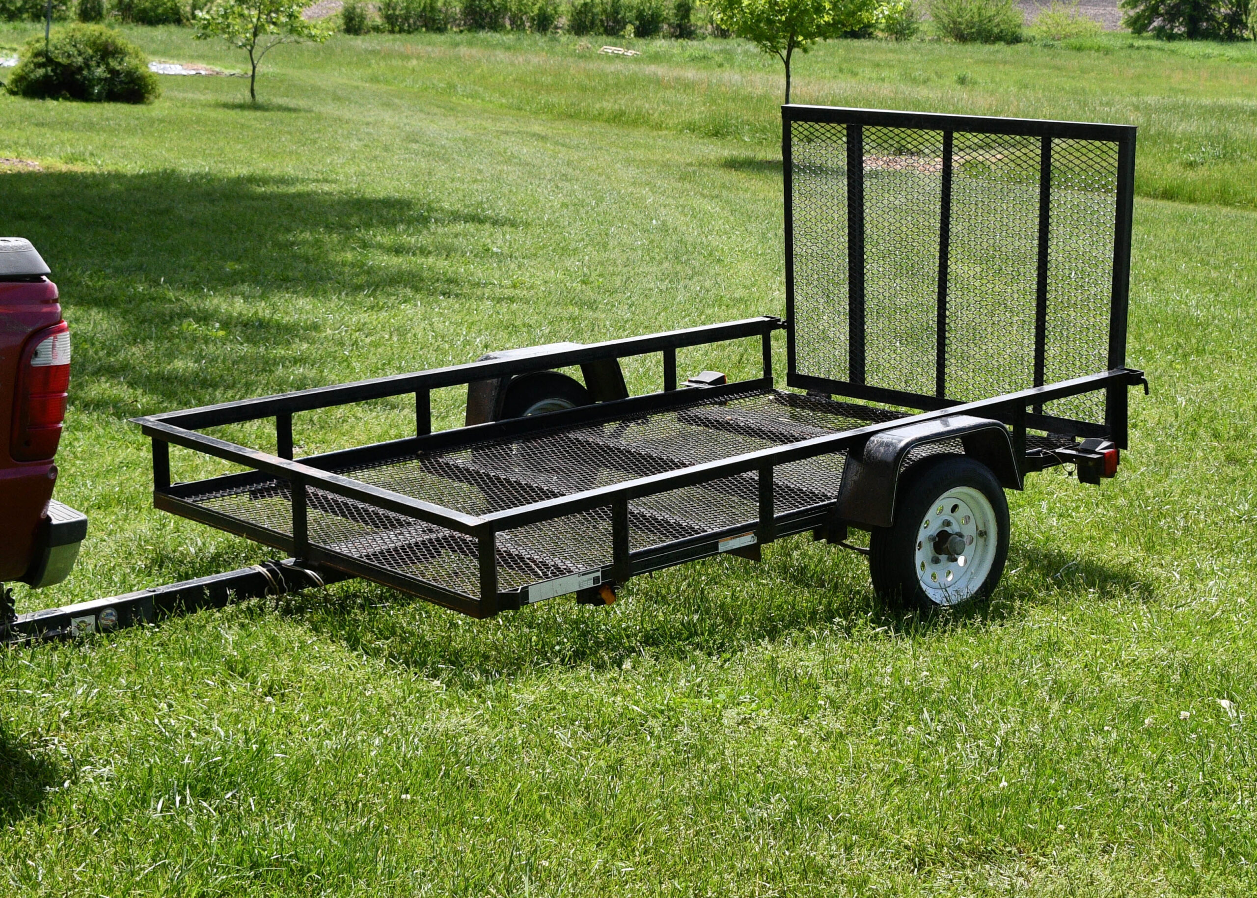 utility trailer with mesh bed from trs equipment rental on a green grass