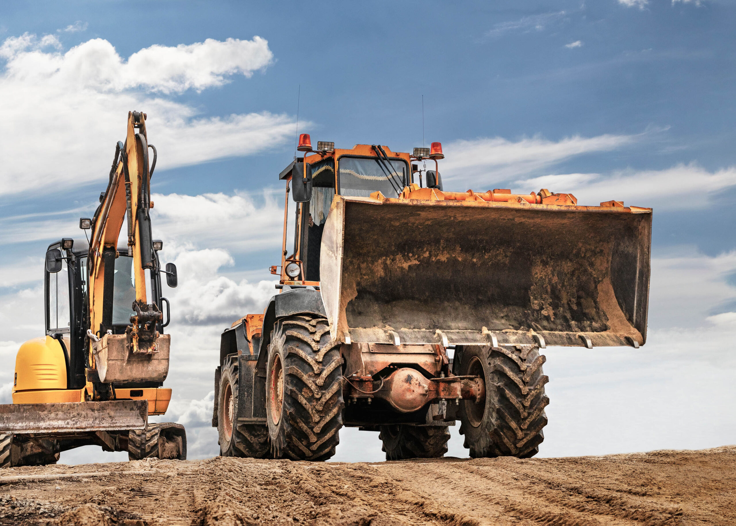 wheel loader and excavator from trs equipment rental parked on a site for seasonal uses