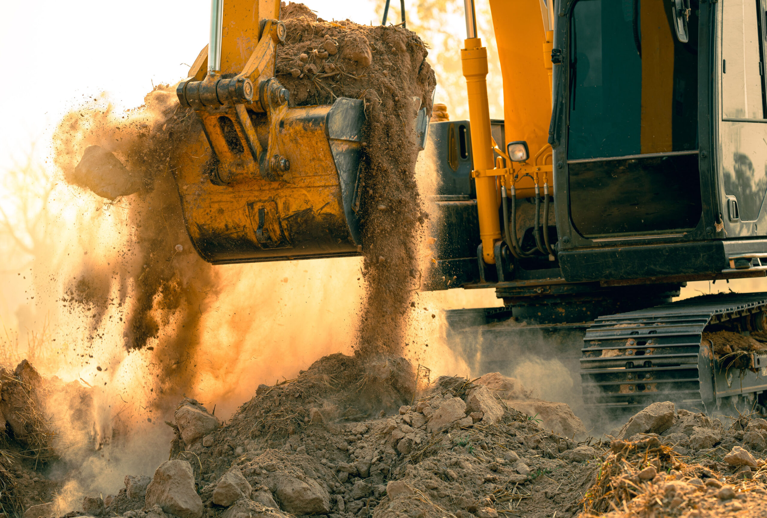 close view of excavator from trs equipment rental carrying soil at construction site