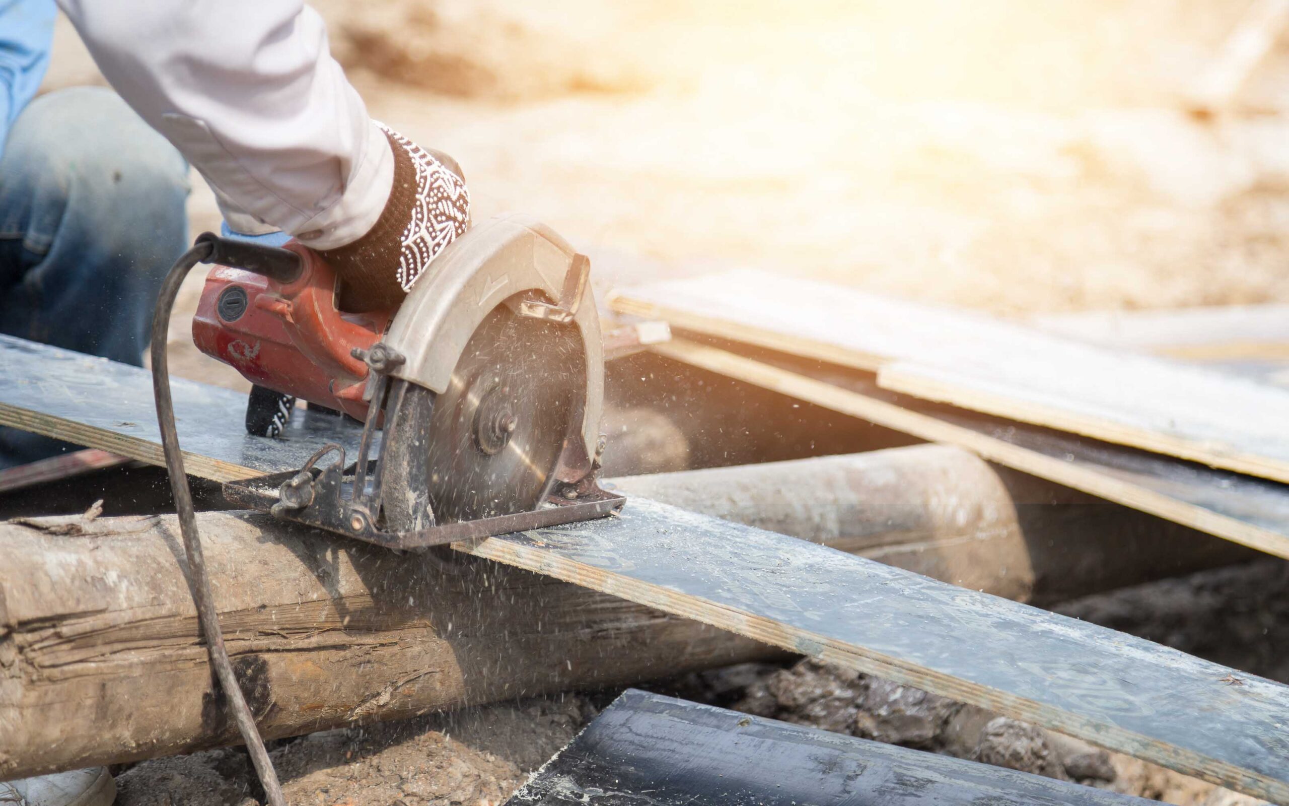 Worker cutting plywood by electric saw,construction work.