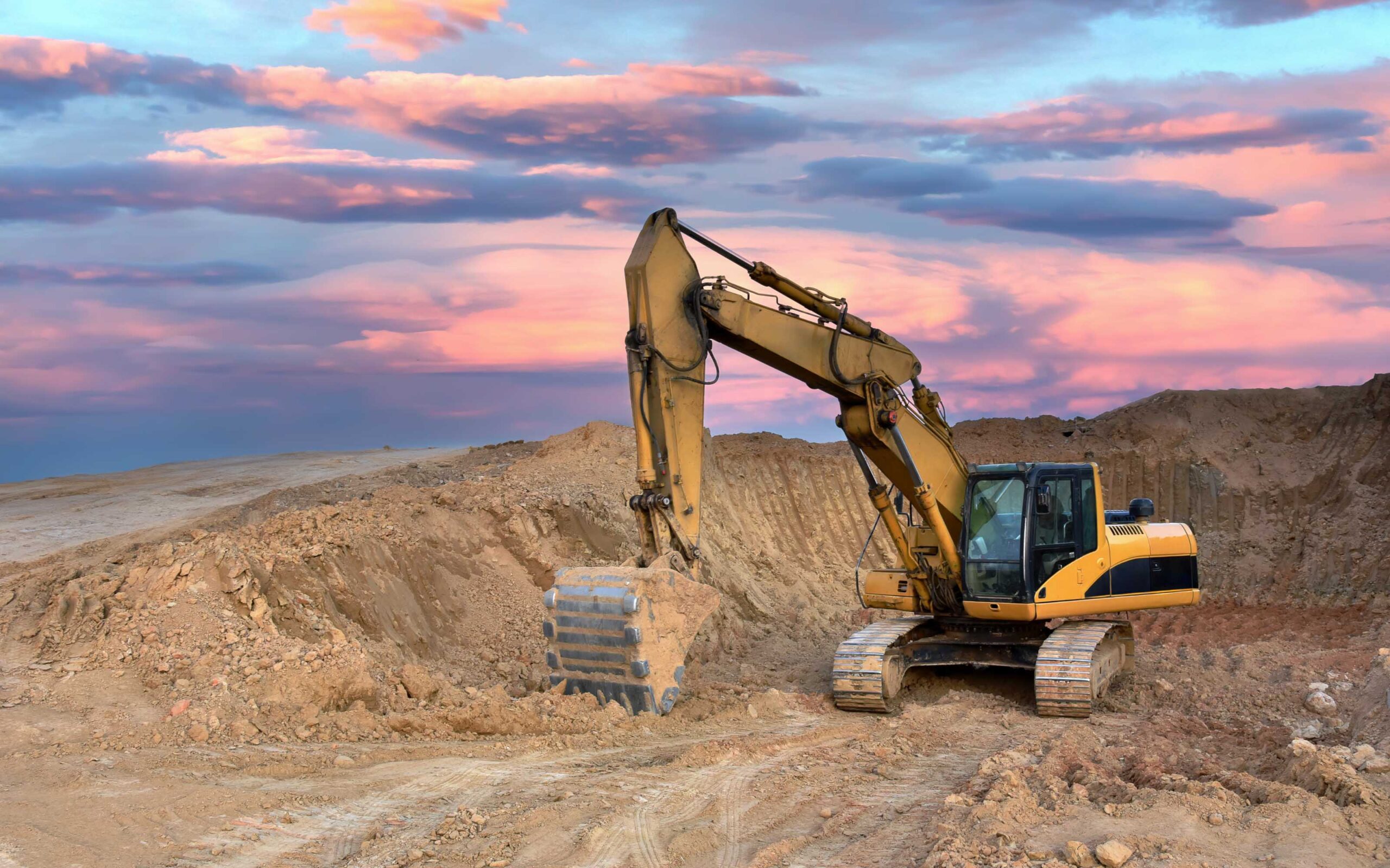 Excavator on sunset background. Open-pit mining. Backhoe dig ground in quarry. Heavy construction equipment on excavation on construction site. Excavator on groundwork on dramatic twilight.