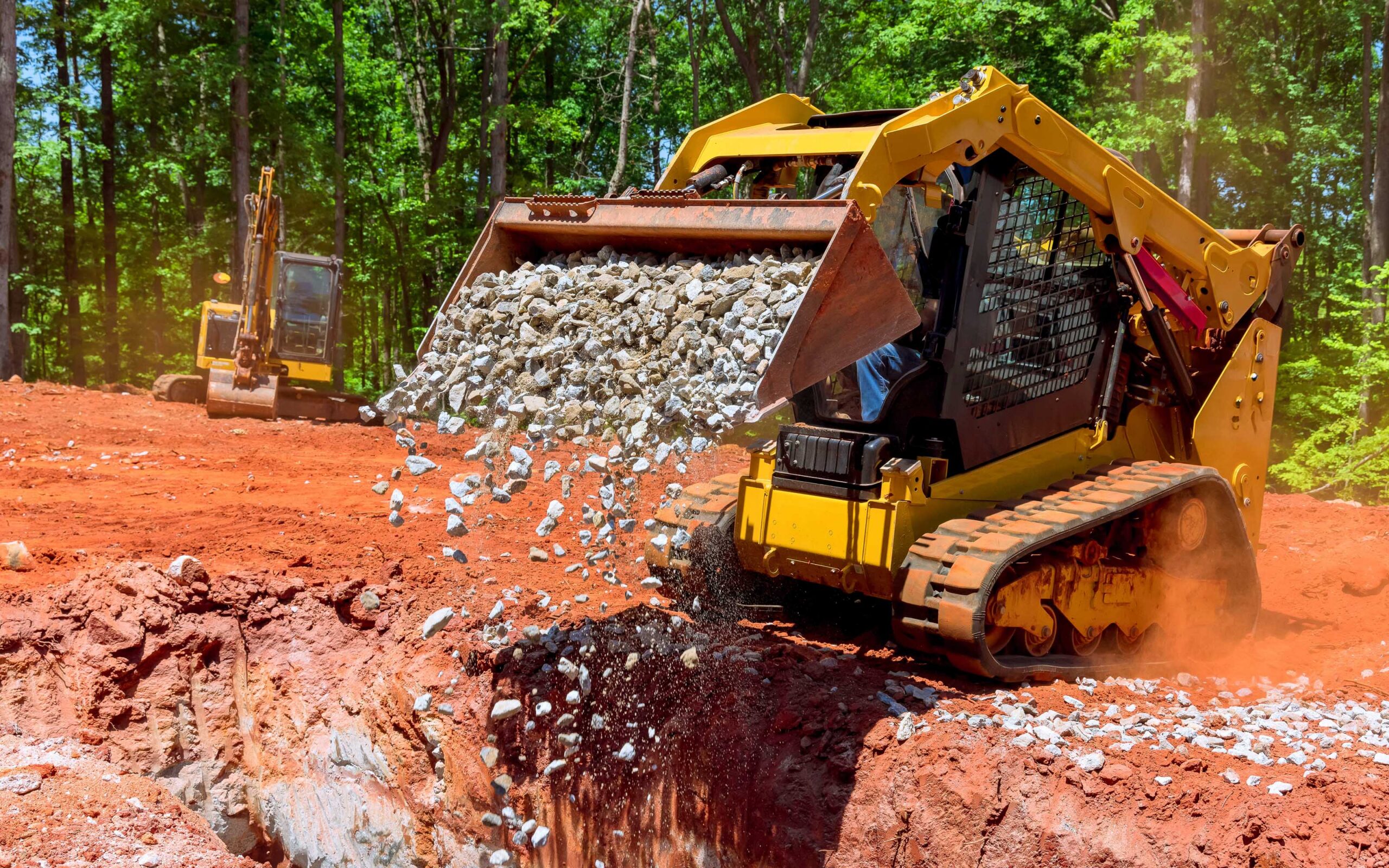 Unloading gravel with an excavator bucket skid steer loader during construction project