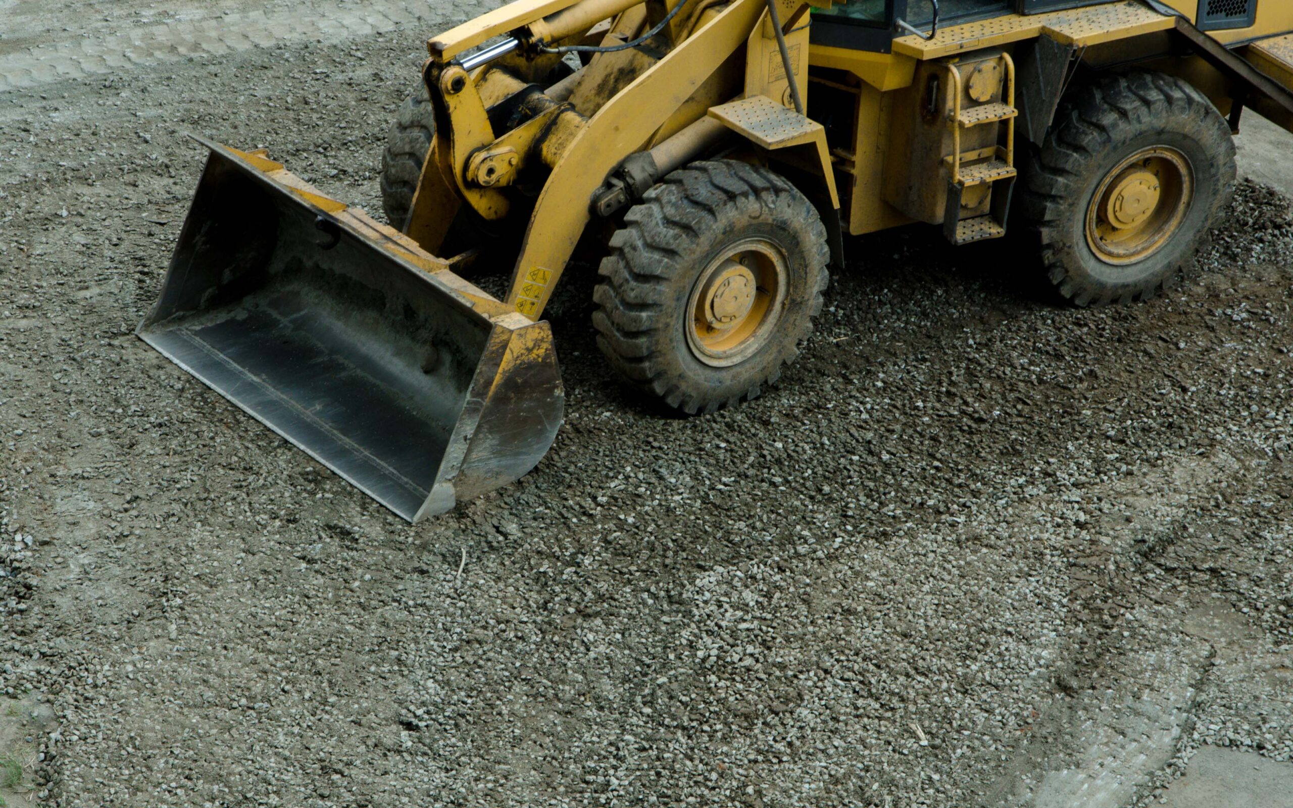 the tractor is leveling the road from the stones
