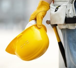 man holding a hard hat on a Safe Construction Site