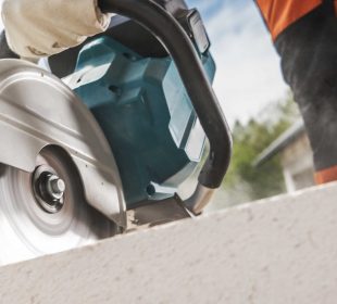 Concrete saw cutting through concrete during construction, illustrating a concrete saw vs. jackhammer comparison for concrete cutting and demolition.